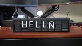 Adam holding his initial 8-character split-flap display.