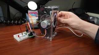 Clear acrylic model demonstrating the internal workings of a split-flap display.