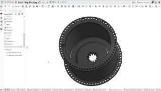 A 3D CAD rendering of the redesigned split-flap drum with 64 holes.