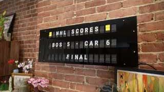 The display showing dynamic NHL scores: BOS 5 - CAR 6 FINAL.