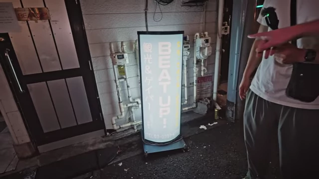 A standing signboard for a "kankou" bar in Japanese, indicating it's open to all