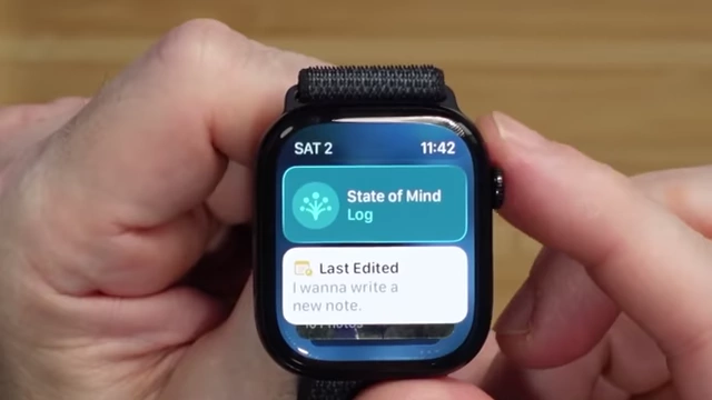 A close-up of an Apple Watch demonstrating the Smart Stack feature, showing dynamic widgets like "State of Mind Log" and "Last Edited" notes when scrolling the Digital Crown.