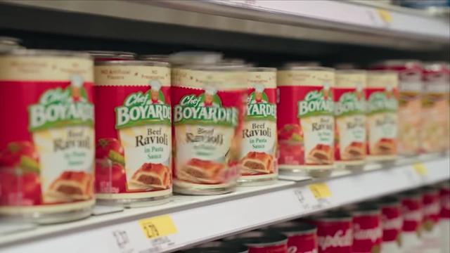 Cans of Chef Boyardee on a store shelf, part of an elaborate "chef recreation" segment.