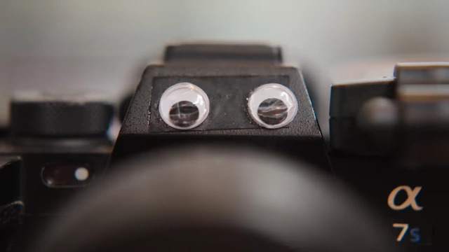 A camera with googly eyes, personifying the "black void of a lens" that causes filming anxiety.