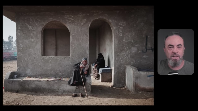A man with a cane sits in the foreground, while a woman sits deeper within an archway in the background, illustrating depth, implied symmetry, and storytelling tension.