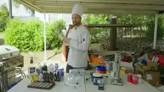 William Osman standing with a table full of ingredients and equipment for the Coca-Cola replication.