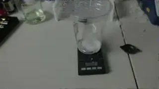 A digital scale measuring 37.1 grams of sugar, the amount for one 12oz can of Coke.