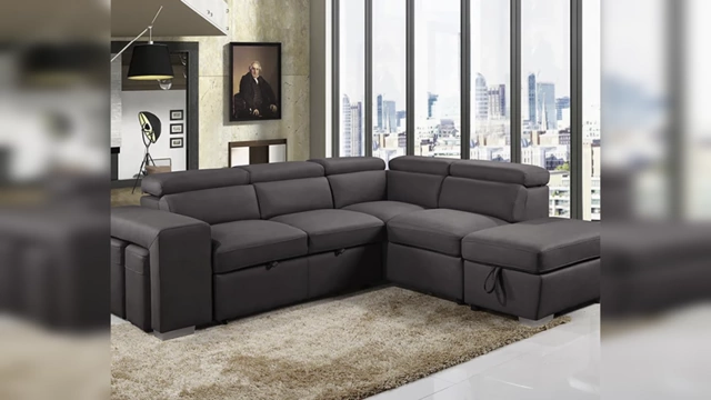 A living room featuring a large, dark grey sectional sofa with built-in recliners, typical of bulky, comfort-focused "dad furniture" that often makes a space look cheap.