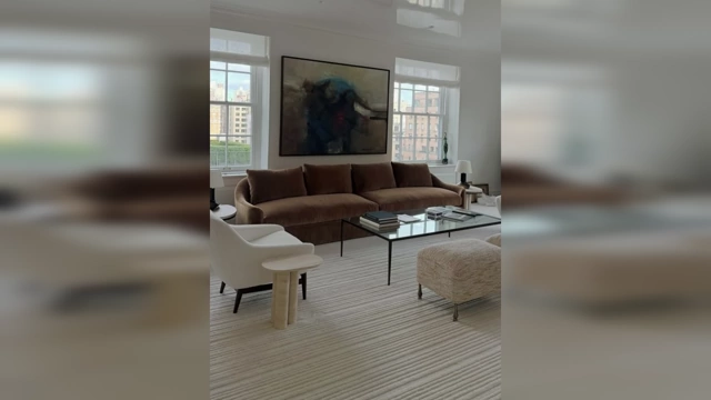 A contemporary living room featuring a sleek, comfortable brown sofa, a glass coffee table, and white accent chairs, demonstrating balanced aesthetics and comfort.
