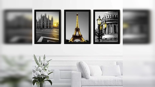 A set of three black and white generic canvas prints featuring famous European landmarks above a sofa, illustrating uninspired decor.