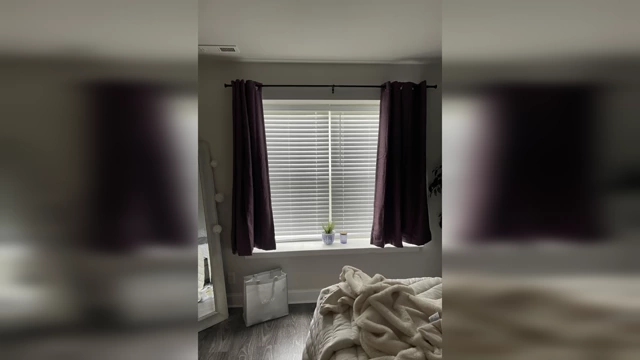 A bedroom with curtains that are too short and narrow for the window, creating an awkward and unfinished look.