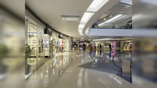 A modern shopping mall interior with high-gloss floors reflecting light, creating a cold and impersonal atmosphere.