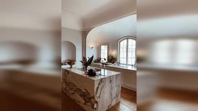 A luxurious kitchen featuring a solid marble island with striking natural veining.