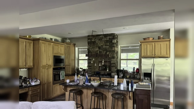 A kitchen with cabinets that don't reach the ceiling, where the space above is cluttered with decorative items.