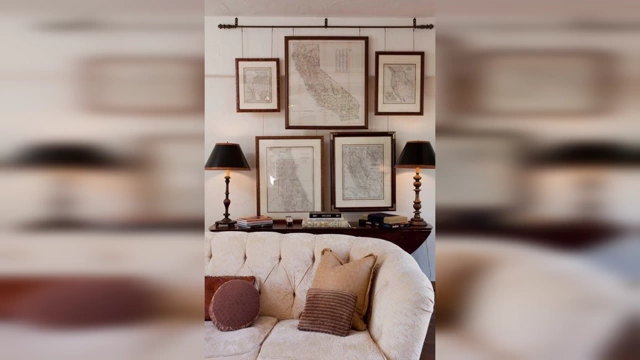 A wall display featuring multiple framed vintage maps above a sofa, adding a personal and cultured touch.