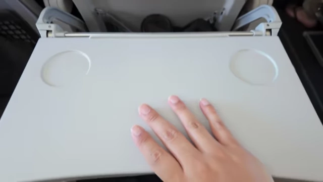 A small airplane tray table, highlighting the challenge of using a large laptop during flights