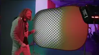 A green screen with a subject in front, demonstrating the concept of selecting a chroma value for transparency.
