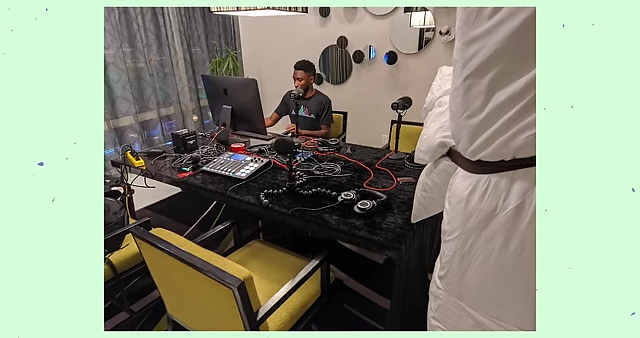 A makeshift sound setup in a hotel, using a bed cot as a sound blanket for acoustic dampening