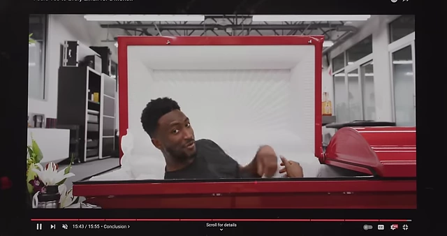 Marques laying in the casket and sealing it, a humorous alternative to the usual lens cover