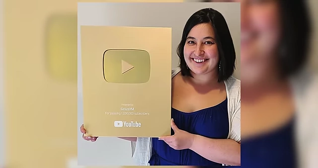 Harper proudly holding a Gold Play Button for SiriusXM's YouTube channel