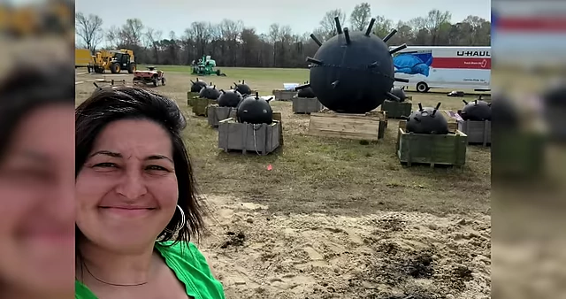 Harper taking a selfie in a field with large prop mines, showcasing her hands-on production experience