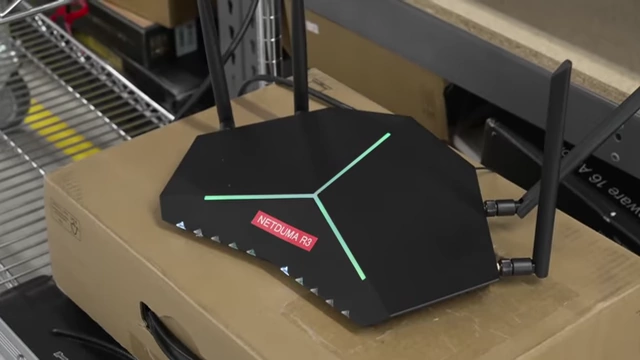 一款带有绿色发光图案的黑色路由器，标签上写着“NETDUMA R3”