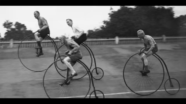 People riding vintage high-wheel bicycles