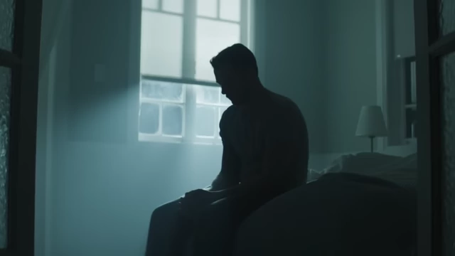 A lone figure sits in a dimly lit room, symbolizing the social isolation of hikikomori.