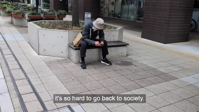A man sitting alone on a bench with text "Once you went off the rails, it's so hard to go back to society", illustrating the difficulty of reintegrating into society after prolonged isolation.