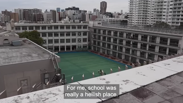 An aerial view of a Japanese school campus with text 'For me, school was really a hellish place', emphasizing the intense pressure experienced by students.