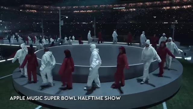 Kendrick Lamar surrounded by dancers forming a circle on stage