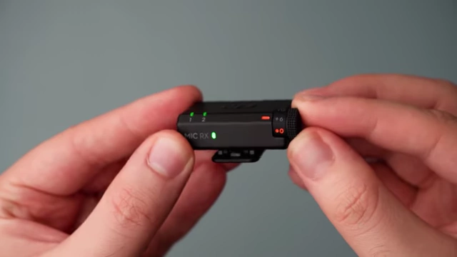 Close-up of the DJI Mic Mini receiver showing physical audio gain switches.