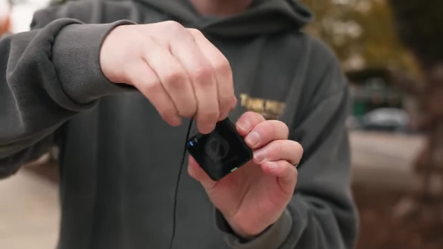 A Rode Wireless Pro transmitter with a lavalier microphone connected using a twisting lock mechanism.
