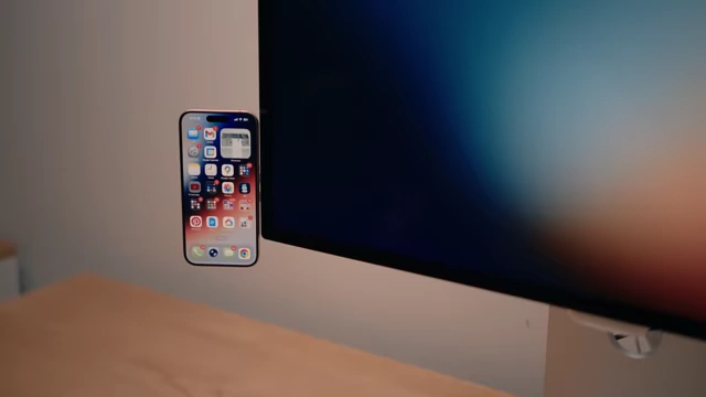 iPhone attached to a MagSafe charger mount on the side of a monitor