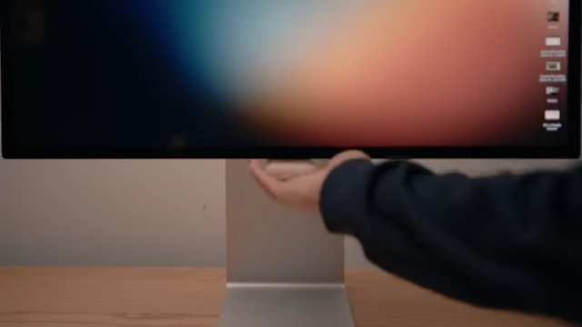 AirPods charging on a custom-designed MagSafe mount hidden behind a monitor
