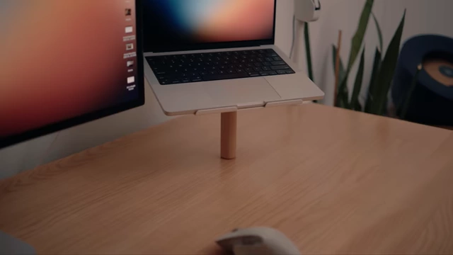 Laptop on a stand that is drilled directly into the desk, showcasing a clean setup