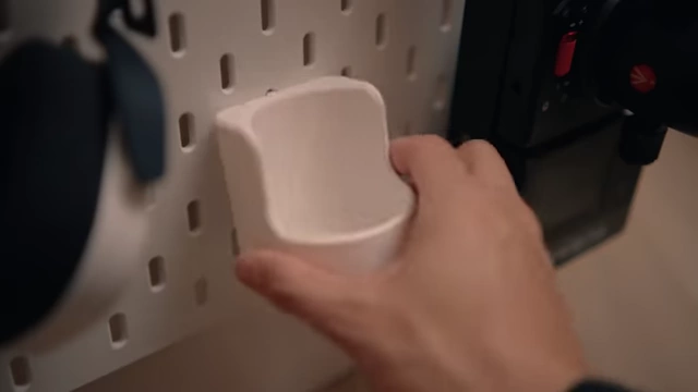 A 3D printed headphone holder attached to the SKADIS pegboard