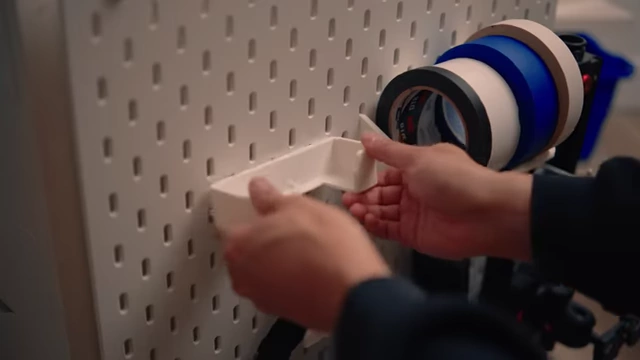 A 3D printed tape holder attached to the SKADIS pegboard, holding multiple rolls of tape