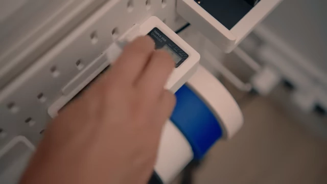 A slider battery charger being inserted into its custom 3D printed holder on the SKADIS pegboard