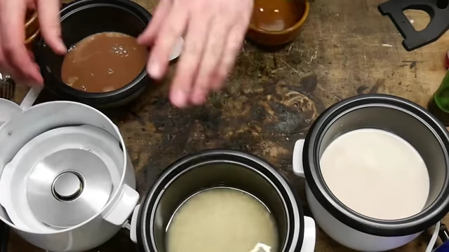 Rice cookers prepared with Pilk, Sake, and Yoo-hoo mixtures for cooking.