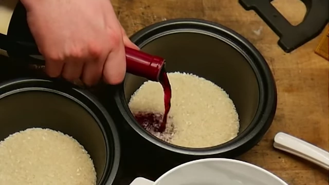 Pouring red Josh wine into a rice cooker with rice.