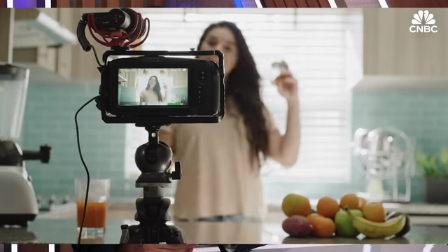 Fitness influencer filming a healthy meal prep in a kitchen