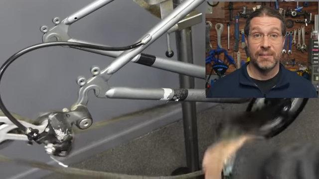 The speaker adjusting components on a bicycle, symbolizing the hands-on and physical nature of his work.