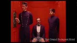 A symmetrical shot from The Grand Budapest Hotel, showing characters perfectly centered in a red room.