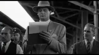 A black and white tracking shot following a man walking, creating an immersive sense of movement.