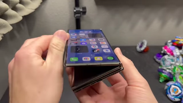 The Huawei Mate XT partially folded, showing the "spring back" action of its hinges.
