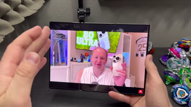 A video playing on the Huawei Mate XT screen showing a brief drop in quality when a volume adjustment pop-up disappears.