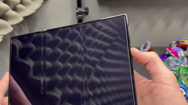 A fingernail pressing the fingerprint scanner, a method the reviewer uses to ensure the lock screen notifications are shown.