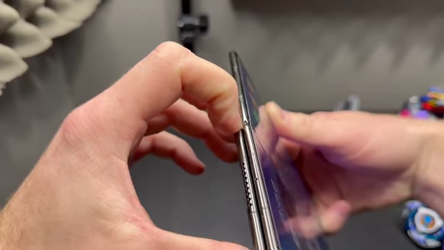 Hands attempting to open the Huawei Mate XT from the side, demonstrating the strong magnetic hold.