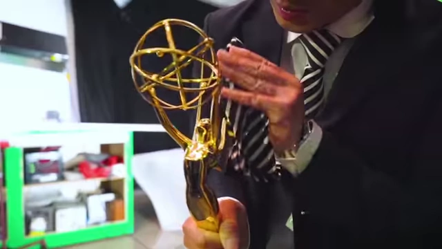 Chris Do holding an Emmy award, signifying his achievements and expertise.